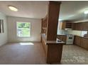 Eat-in kitchen featuring custom cabinetry, open view window, and laminate flooring at 44112 Harper Hearne Rd, New London, NC 28127