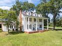 Charming two-story white home with a welcoming front porch, dark shutters, and a red brick chimney at 550 Woodleaf Barber Rd, Cleveland, NC 27013