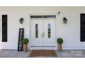 Elegant double front doors with glass panels, flanked by sconces and decorative plants, and a 'Welcome' sign at 550 Woodleaf Barber Rd, Cleveland, NC 27013