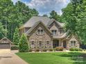 A two-story stone house with landscaped front yard and separate garage, embodying suburban charm at 631 May Green Dr, Clover, SC 29710