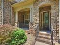 Charming stone front porch with decorative columns, steps and well-maintained landscaping at 631 May Green Dr, Clover, SC 29710