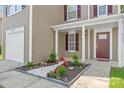 Inviting front porch with a decorative flowerbed, complemented by white stone and colorful plants at 6430 Matlea Ct, Charlotte, NC 28215