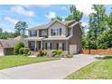 Lovely two-story home with an extended driveway leading to an attached garage, complemented by a well-maintained lawn at 7355 Drury Ln, Denver, NC 28037