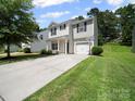 Two-story home with an attached one car garage and long driveway at 8516 Paw Valley Ln, Charlotte, NC 28214