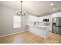 Bright kitchen features white cabinets, quartz countertops, and stainless steel appliances at 8516 Paw Valley Ln, Charlotte, NC 28214