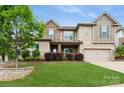 Charming two-story home with a lush lawn, shrubbery, and attached two car garage at 1026 Arges River Dr, Fort Mill, SC 29715