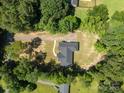 An aerial view showing the well maintained roof and surrounding wooded neighborhood at 108 Woodwinds St, Locust, NC 28097