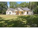 Inviting single-story home featuring a landscaped yard, craftsman style architecture, and covered front entrance at 108 Woodwinds St, Locust, NC 28097