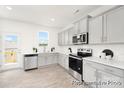 Bright kitchen featuring stainless steel appliances, gray cabinets, white countertops, and access to the outdoor deck at 11712 Avocet St # 76, Charlotte, NC 28215