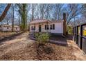 Cozy white home surrounded by trees, featuring a charming covered porch at 1229 Jenkins St, Rock Hill, SC 29732