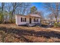 Cute white home with covered porch nestled among mature trees in a quiet neighborhood at 1229 Jenkins St, Rock Hill, SC 29732