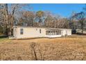 Single story home featuring a front screened in porch and two car garage with a gravel driveway at 1295 Reservation Rd, Rock Hill, SC 29730