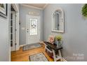 Welcoming entryway features hardwood floors, a decorative mirror, and a charming bench with storage basket at 134 Cherry Bark Dr, Mooresville, NC 28117