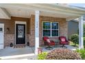 Inviting covered front porch with brick pillars, comfortable seating, and stylish decor that exudes curb appeal at 134 Cherry Bark Dr, Mooresville, NC 28117