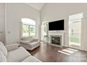 Bright living room with fireplace, large windows, hardwood floors, and comfortable seating at 14130 Misty Brook Ln, Charlotte, NC 28273