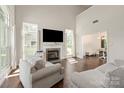 Bright living room with fireplace, large windows, hardwood floors, and comfortable seating at 14130 Misty Brook Ln, Charlotte, NC 28273