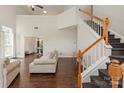 Spacious living room featuring hardwood floors, a staircase, and neutral-toned furniture at 14130 Misty Brook Ln, Charlotte, NC 28273