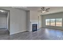 Bright living room featuring a fireplace, wood-style floors, and large windows for natural light at 159 Apple Orchard Ct, Statesville, NC 28677