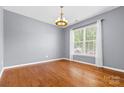 A bright dining room features gleaming hardwood floors, neutral walls, and a modern chandelier at 159 E Warfield Dr, Mooresville, NC 28115