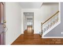 Hardwood floors lead into a hallway and carpeted stairs; natural light flows in from a door on the left at 159 E Warfield Dr, Mooresville, NC 28115
