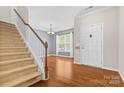 Inviting entryway with hardwood floors, staircase and a view into the dining area with natural light at 159 E Warfield Dr, Mooresville, NC 28115