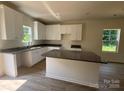 Bright kitchen with granite counters, an island and white cabinetry at 1727 E Cloaninger Ave, Statesville, NC 28625