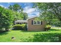Well-maintained brick house with lawn, mature trees offering shade at 2215 Hodgin St, Gastonia, NC 28056