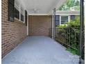 Covered front porch with brick wall and metal railing at 2215 Hodgin St, Gastonia, NC 28056