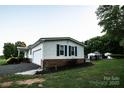 Single story home with white siding, blue shutters, and a two-car garage at 34107 Watson Rd, Albemarle, NC 28001