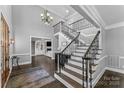 Grand two-story foyer with staircase, chandelier, dark hardwood floors, and decorative iron railings at 3916 2Nd Street Nw Dr, Hickory, NC 28601
