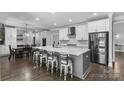 Spacious kitchen features a large island with seating, white cabinets, stainless steel appliances, and hardwood floors at 3916 2Nd Street Nw Dr, Hickory, NC 28601