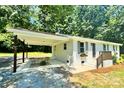 Inviting single-story brick home with a convenient carport and an outdoor seating area at 617 Rock Hill Church Rd, Matthews, NC 28104