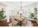 Bright dining room with modern chandelier, wainscotting and views to the backyard through French doors at 646 Quicksilver Trl # 183, Fort Mill, SC 29708