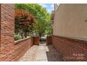 Brick-walled pathway and gated entrance, with manicured landscaping and trees at 6602 Gaywind Dr, Charlotte, NC 28226