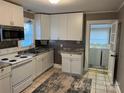 Well-lit kitchen features white cabinets, stainless steel appliances, tile backsplash, and updated countertops at 706 13Th Sw St, Hickory, NC 28602