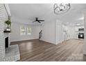 Spacious living room with wood-look floors, fireplace, modern lighting, and open layout to the kitchen at 7219 Spring Morning Ln, Charlotte, NC 28227