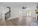 Bright living area with fireplace, ceiling fan, access to the deck, and staircase to the second level at 7219 Spring Morning Ln, Charlotte, NC 28227