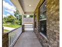 View of the charming covered front porch with white railings and brick accents at 7717 Nautical View Dr, Denver, NC 28037