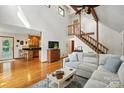 Open-concept living area featuring wood floors, vaulted ceilings, and seamless flow into the adjacent kitchen at 1119 Palmyra Dr, Fort Mill, SC 29708