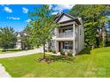 Charming two-story home with a front porch, a manicured lawn, and mature trees at 120 Carolinian Dr, Statesville, NC 28677