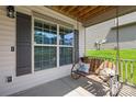 Relaxing porch with a cozy swing and decorative pillows, creating a serene outdoor space at 120 Carolinian Dr, Statesville, NC 28677