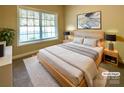Comfortable bedroom with a large window, soft carpet, and stylish bed frame and linens at 1228 N Dobys Bridge Rd, Fort Mill, SC 29715