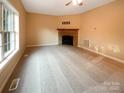 Bright, empty living room featuring neutral walls, carpet flooring, and a stone fireplace at 1228 N Dobys Bridge Rd, Fort Mill, SC 29715