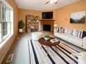Cozy living room with a brick fireplace, large window, and stylish furnishings at 1228 N Dobys Bridge Rd, Fort Mill, SC 29715