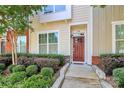 View of front door, with well-maintained landscaping, and brick accents at 2726 Tranquil Oak Pl, Charlotte, NC 28206