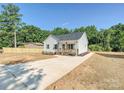 Inviting single-story home with white siding, a covered porch, long driveway, and partially fenced backyard at 286 Old Pinckney Rd, York, SC 29745