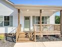 Cozy porch with wooden deck, stairs, railings, and a green front door with sidelight windows at 286 Old Pinckney Rd, York, SC 29745