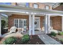 Charming front porch with white columns, comfortable seating and manicured landscaping at 2909 Julian Glen Cir, Waxhaw, NC 28173