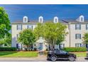 Three-story condo complex with white siding, blue shutters, green trees and lawn at 3849 Carl Parmer Dr, Harrisburg, NC 28075