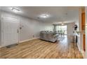 Spacious living room featuring wood floors, modern lighting, and a glass sliding door to the balcony at 3849 Carl Parmer Dr, Harrisburg, NC 28075